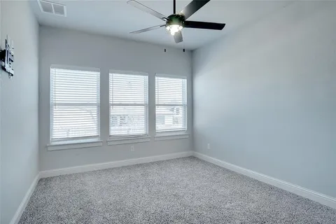 an empty room with a window and a fan
