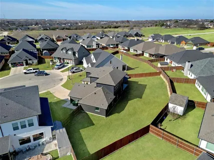 an aerial view of a residential houses with outdoor space and swimming pool