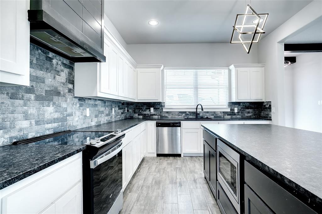 124 William Lane Godley, TX 76044 - Photo 7 of 32 a kitchen with stainless steel appliances granite countertop a sink a stove and cabinets