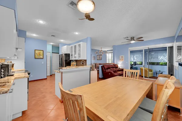 a large kitchen with sink a counter top space appliances and cabinets