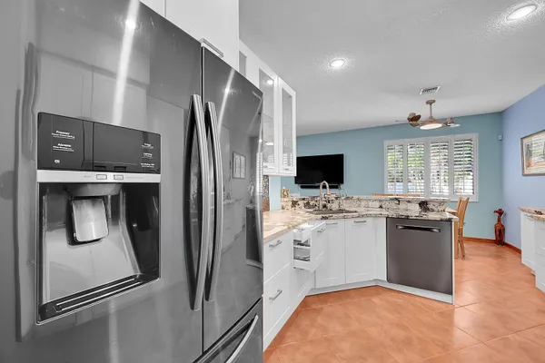 a kitchen with stainless steel appliances granite countertop a refrigerator and a stove top oven