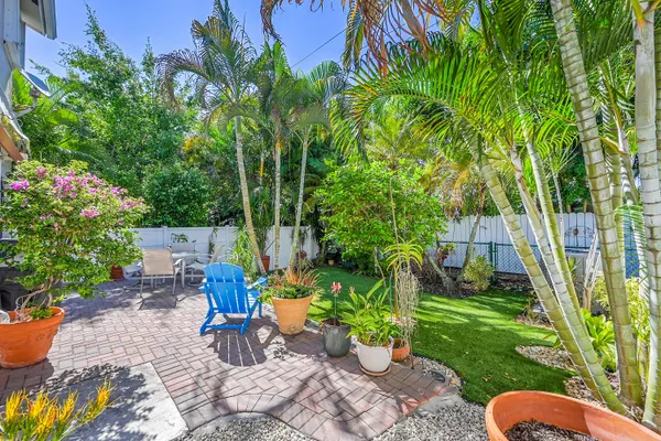a view of a chair and table in backyard of the house