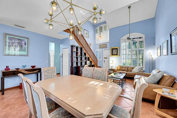 a living room with furniture a dining table and a chandelier