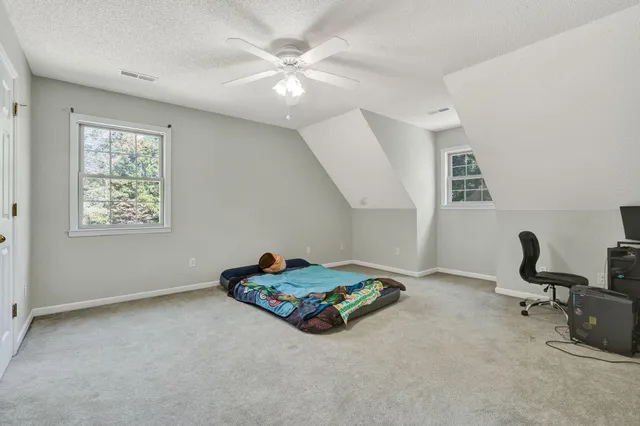 a spacious bedroom with a bed and a chandelier