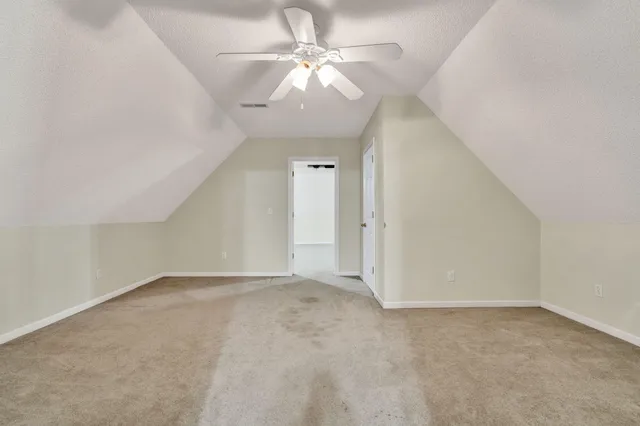 an empty room with a chandelier fan and a large window