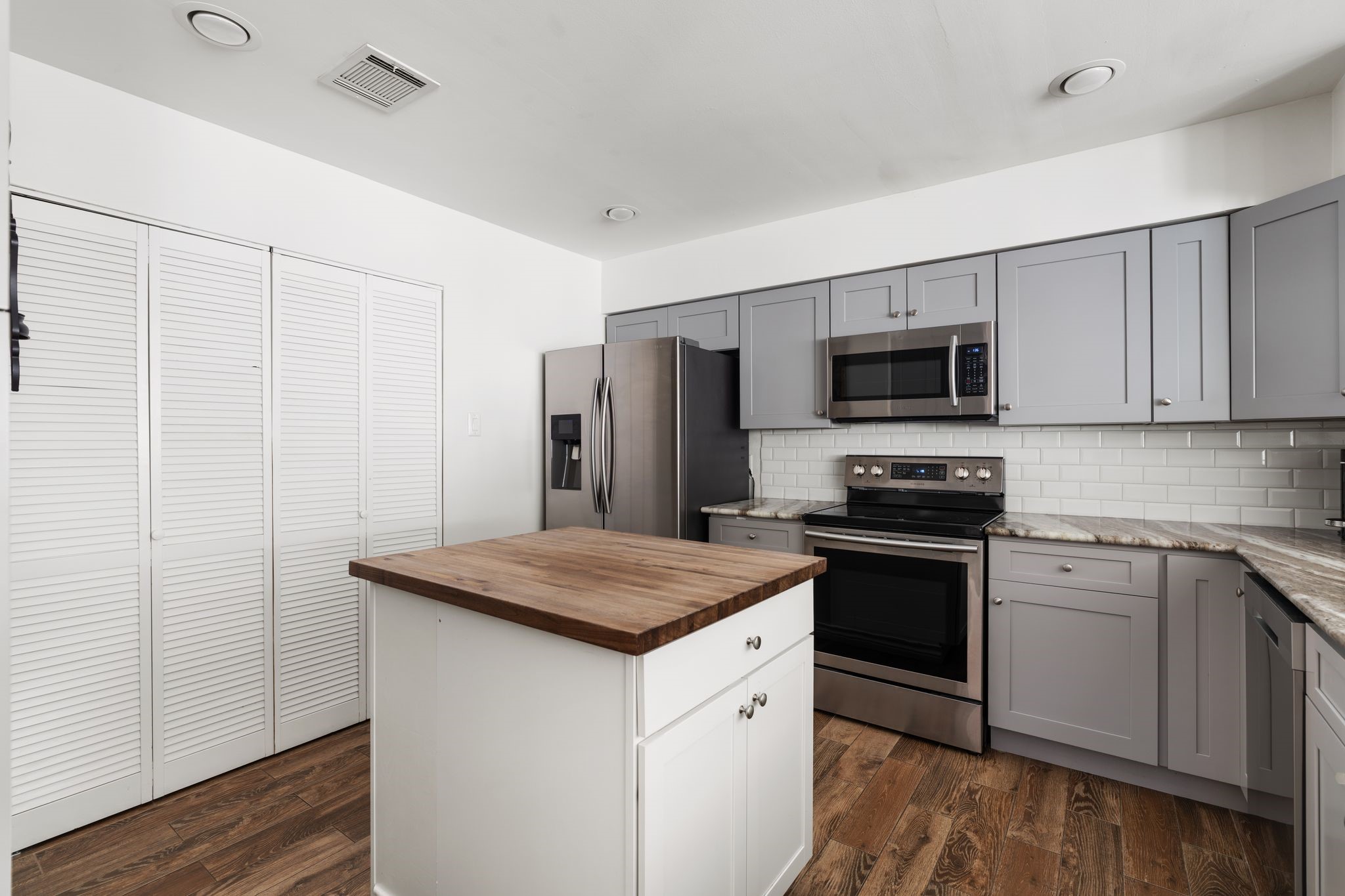 2612 Yupon Street Houston, TX 77006 - Photo 10 of 41 Stainless steel French door refrigerator, expansive island with wood countertops, hidden laundry doors, and abundant cabinetry create a kitchen that blends style and practicality.
