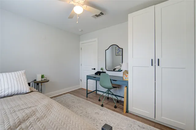 a bedroom with a bed a table and a chandelier