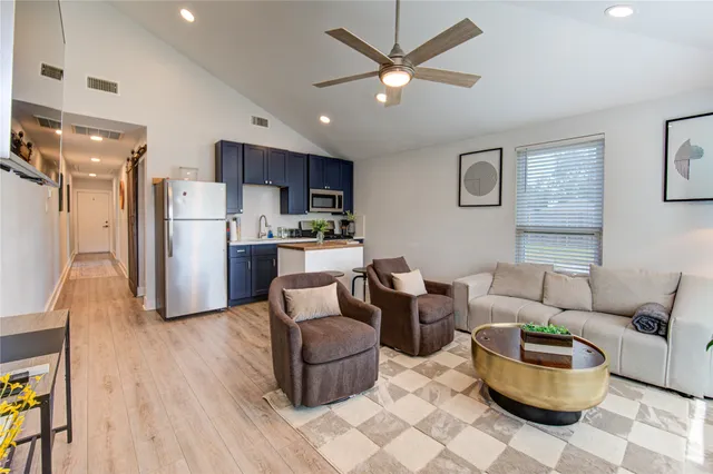 a living room with furniture and a kitchen view