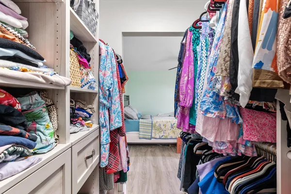 a view of walk in closet with clothes