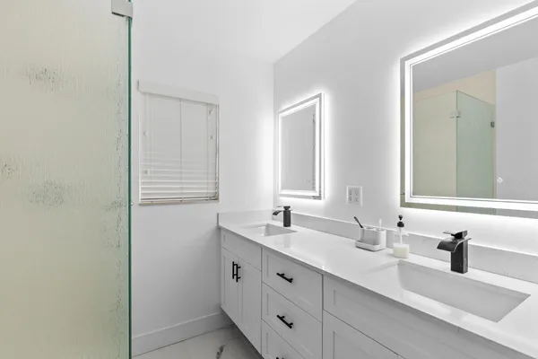 a bathroom with double sink and a mirror