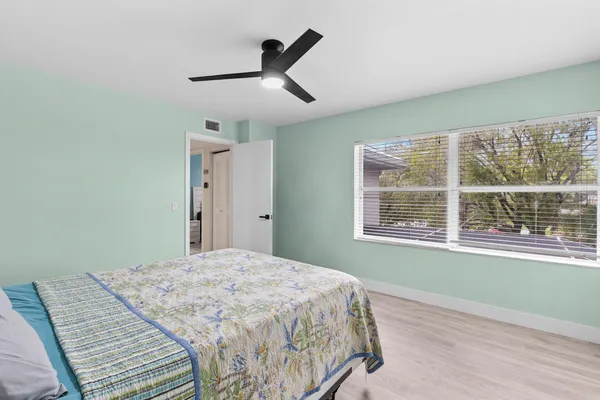 a bedroom with a bed and a large window