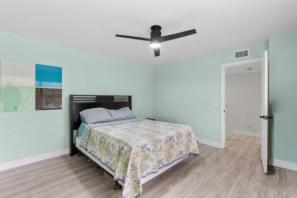 a bedroom with a bed and wooden floor