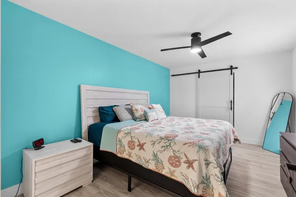 a bedroom with a bed a dresser and a window