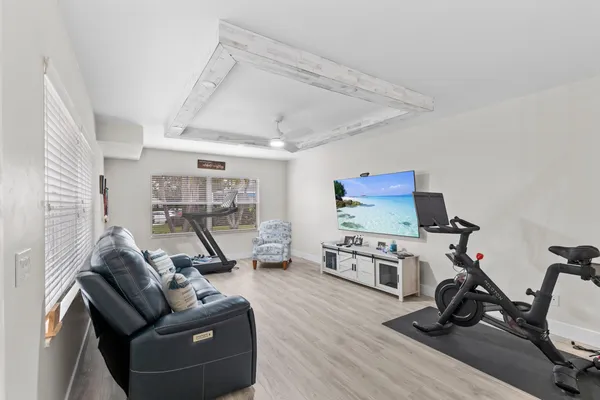a living room with furniture gym equipment and a wooden floor