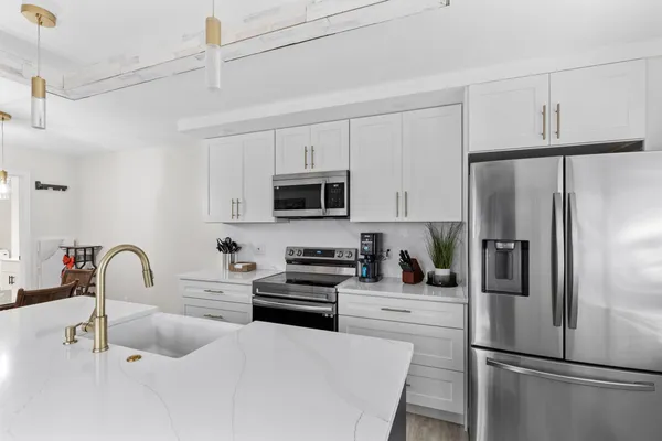 a kitchen with stainless steel appliances a refrigerator sink microwave and cabinets