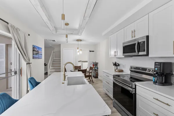 a large white kitchen with stainless steel appliances