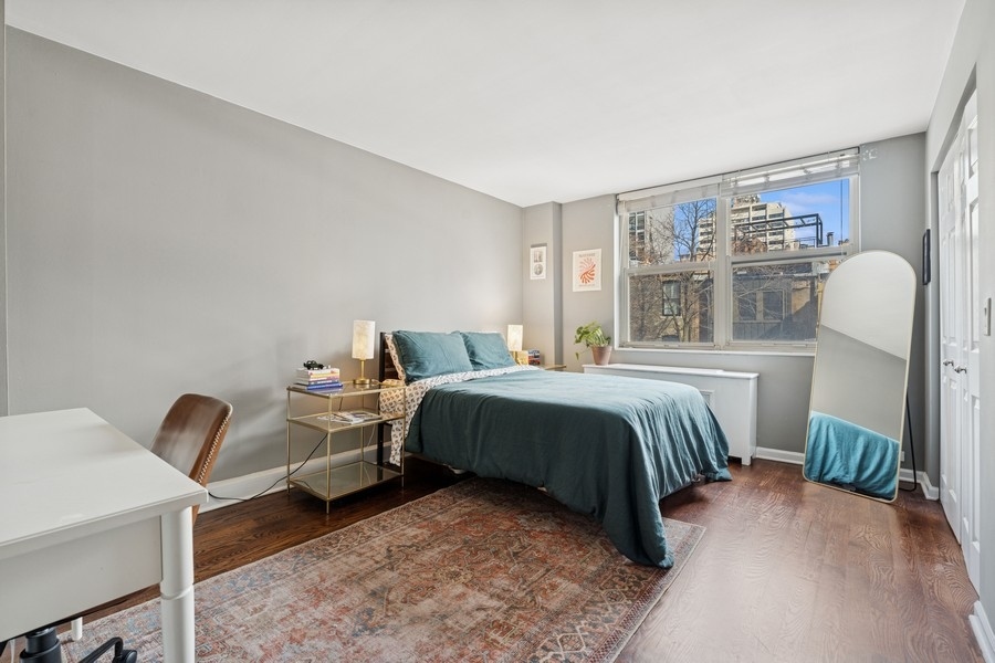 40 East Cedar Street, Unit 4D Chicago, IL 60611 - Photo 11 of 18 a bedroom with a bed and a chandelier