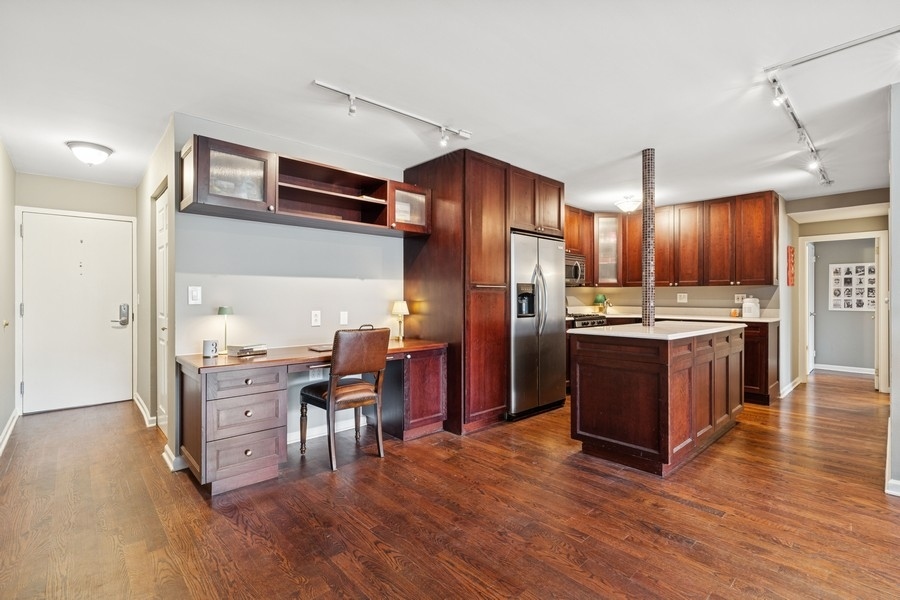 40 East Cedar Street, Unit 4D Chicago, IL 60611 - Photo 4 of 18 a kitchen with stainless steel appliances kitchen island granite countertop wooden floors and wooden cabinets