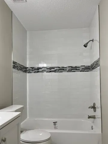 a bathroom with a shower a toilet and a sink