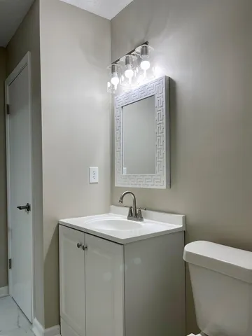 a bathroom with a toilet sink and mirror