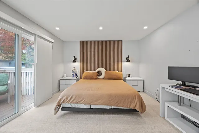 a spacious bedroom with a bed and a flat screen tv