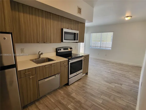 a kitchen with a sink a microwave and cabinets
