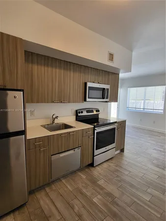 a kitchen with a refrigerator stove and wooden cabinets