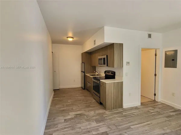 a view of a kitchen with a sink and dishwasher a refrigerator with wooden floor