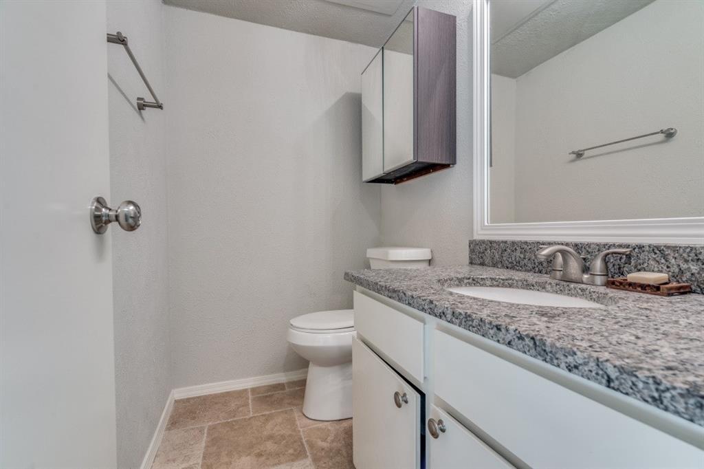 3736 Vitruvian Way, Unit D5 Addison, TX 75001 - Photo 8 of 27 a bathroom with a granite countertop sink a toilet and mirror