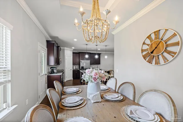 a view of a dining room with furniture a chandelier and a window