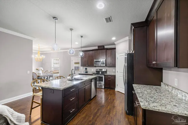 a kitchen with stainless steel appliances granite countertop a sink stove and refrigerator