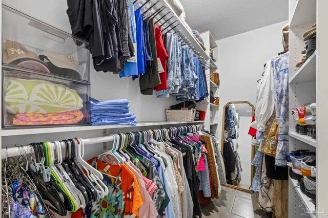 a view of walk in closet with clothes