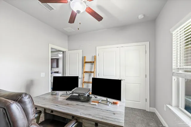 a view of a workspace with furniture and a window