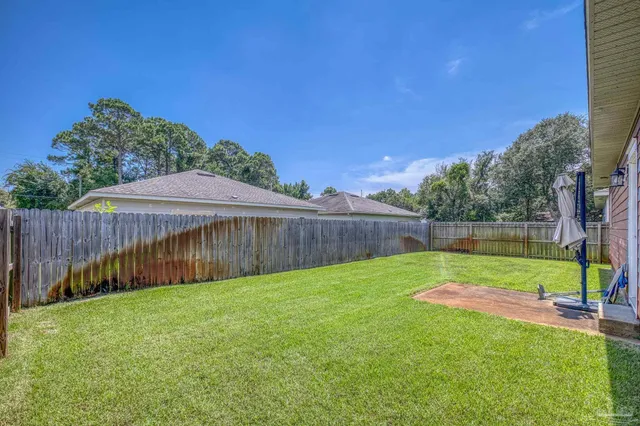 a view of a backyard with a small cabin and wooden fence