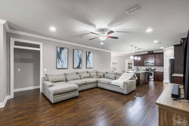 a living room with furniture and a wooden floor
