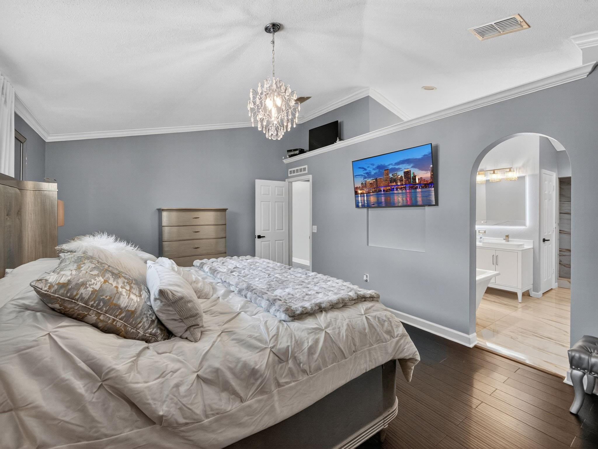 4125 Southwest Webb Street Port St. Lucie, FL 34953 - Photo 11 of 29 a bedroom with a large bed and a chandelier