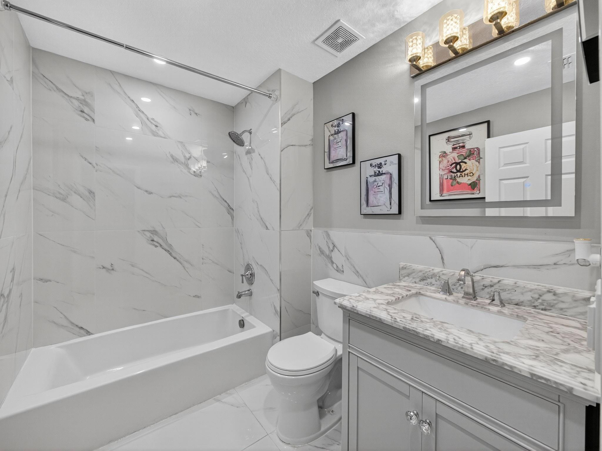 4125 Southwest Webb Street Port St. Lucie, FL 34953 - Photo 19 of 29 a bathroom with a granite countertop sink a toilet and a bathtub