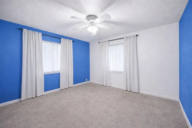 a view of an empty room with a ceiling fan