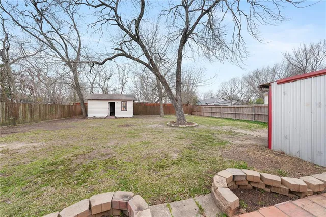 a backyard of a house with table and chairs