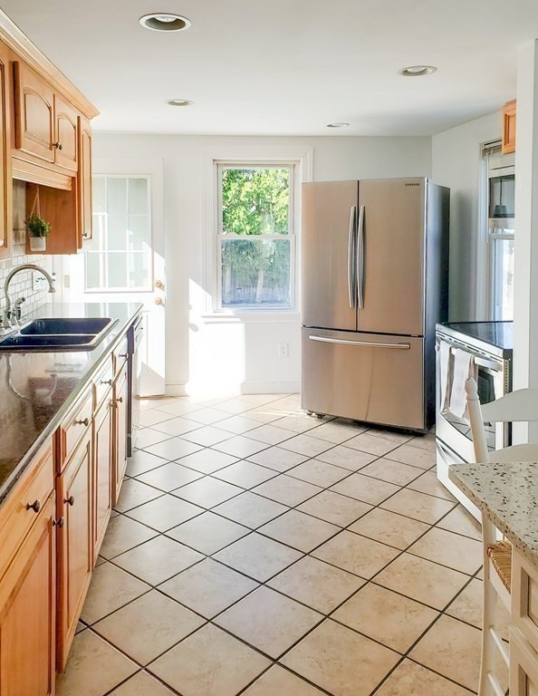 16 Griffin Road Peabody, MA 01960 - Photo 11 of 26 a kitchen with stainless steel appliances granite countertop a refrigerator and a stove top oven
