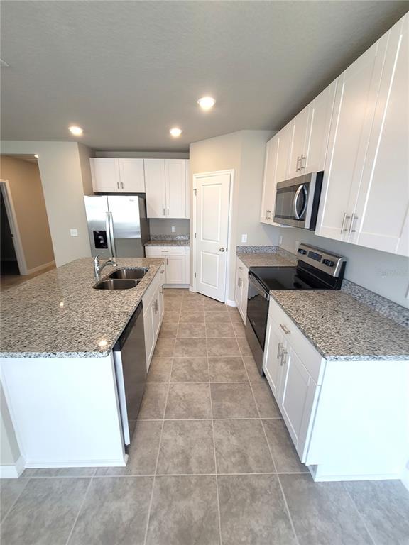 1618 Bark Rdg Drive Auburndale, FL 33823 - Photo 17 of 40 a large kitchen with stainless steel appliances granite countertop a stove a sink dishwasher and a refrigerator