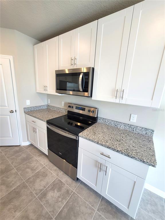 1618 Bark Rdg Drive Auburndale, FL 33823 - Photo 18 of 40 a kitchen with stainless steel appliances granite countertop a sink stove and microwave