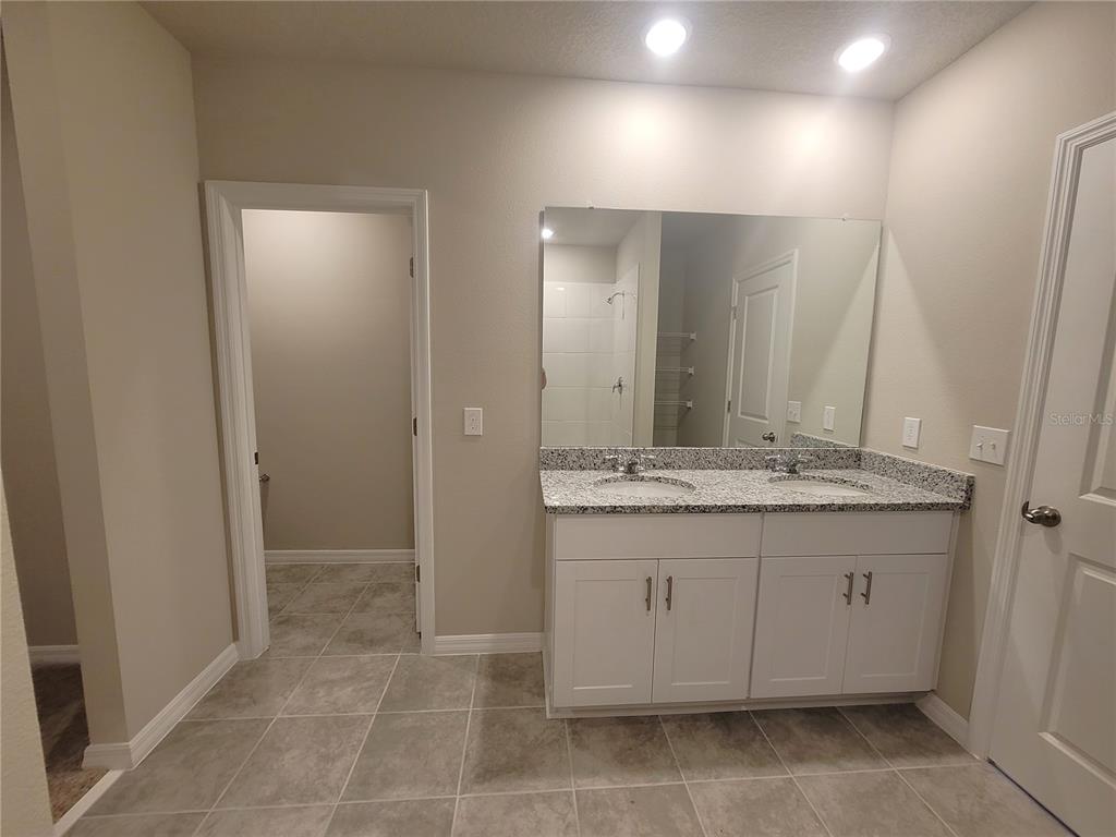 1618 Bark Rdg Drive Auburndale, FL 33823 - Photo 28 of 40 a bathroom with a granite countertop sink and a mirror
