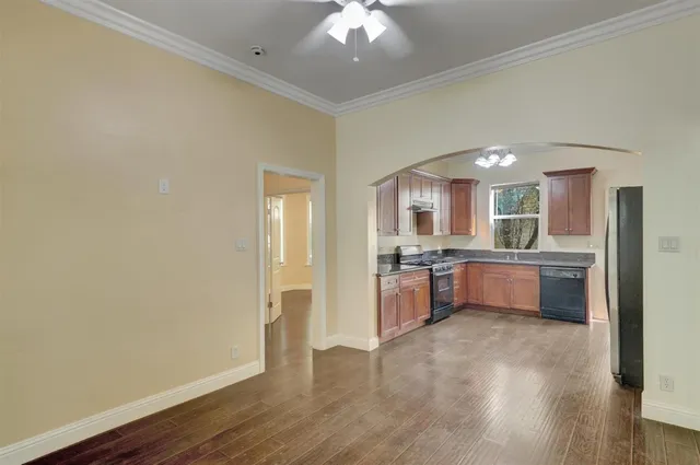 a view of backyard with large trees and wooden fence