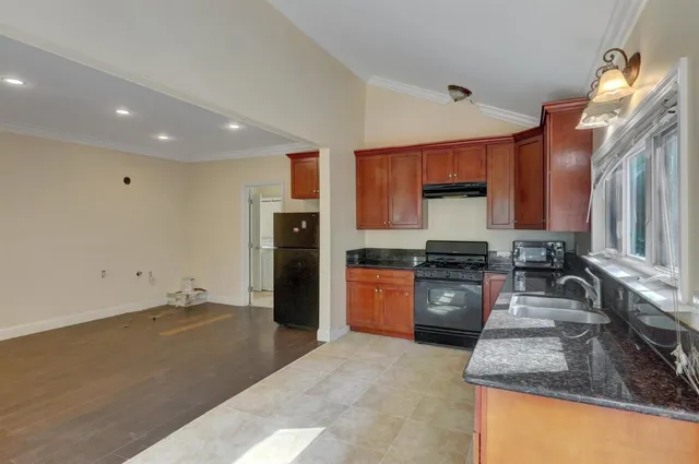 a bathroom with a granite countertop bathtub shower sink and toilet