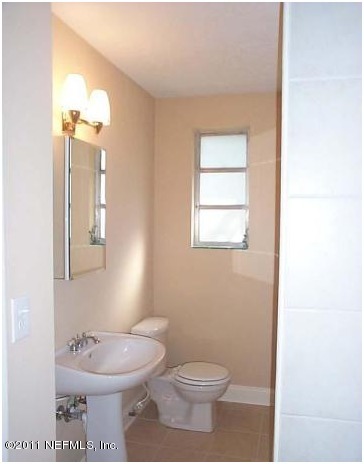 6338 Anvil Road Jacksonville, FL 32277 - Photo 3 of 3 a bathroom with a toilet a sink and a mirror