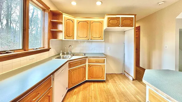 a kitchen with stainless steel appliances granite countertop a sink a stove and a refrigerator