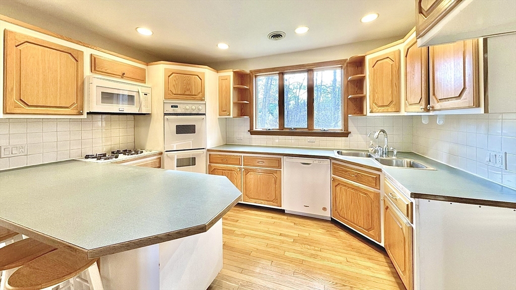 24 Cole Terrace Randolph, MA 02368 - Photo 7 of 40 a kitchen with stainless steel appliances granite countertop a sink a stove and a refrigerator