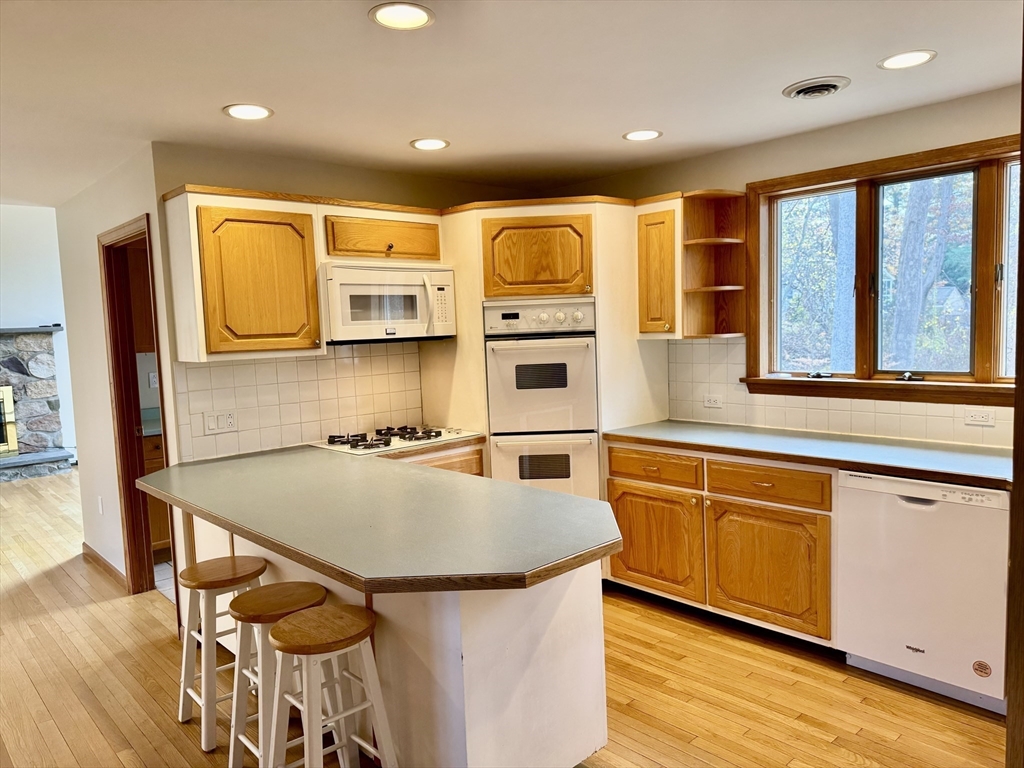 24 Cole Terrace Randolph, MA 02368 - Photo 8 of 40 a kitchen with stainless steel appliances granite countertop a stove a sink dishwasher and a refrigerator with wooden floor