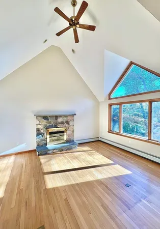 a view of empty room with wooden floor and fireplace